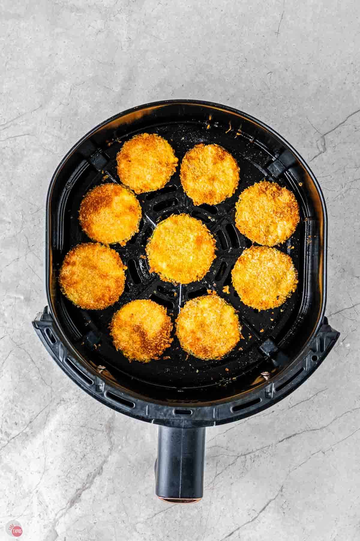 air fried zucchini chips in a black air fryer basket