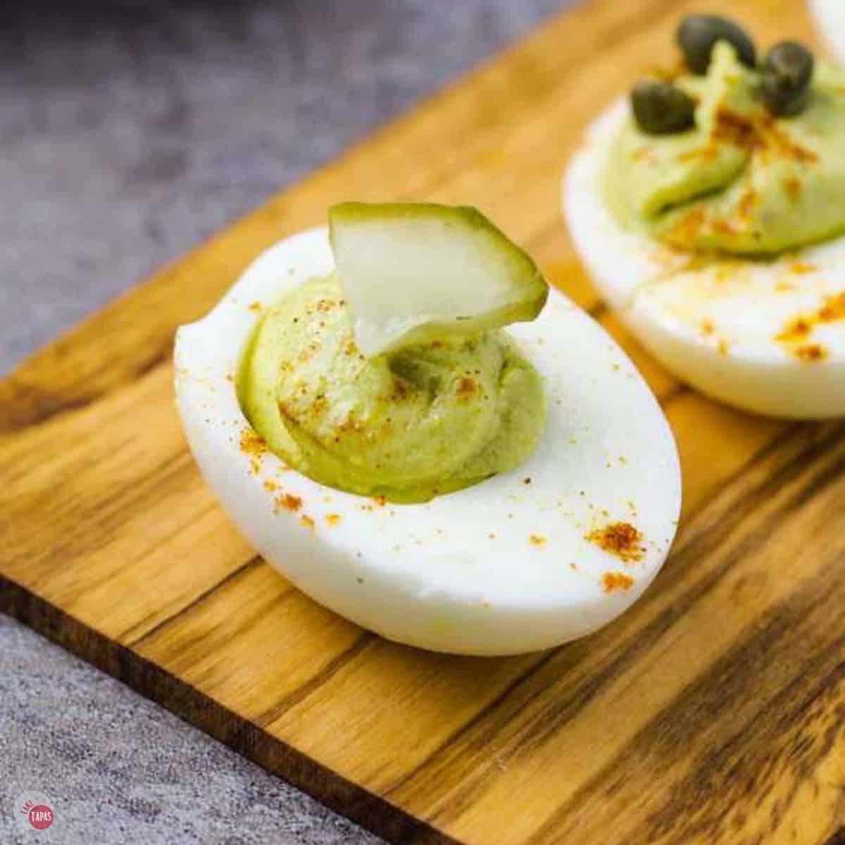 avocado deviled eggs on a wood plank