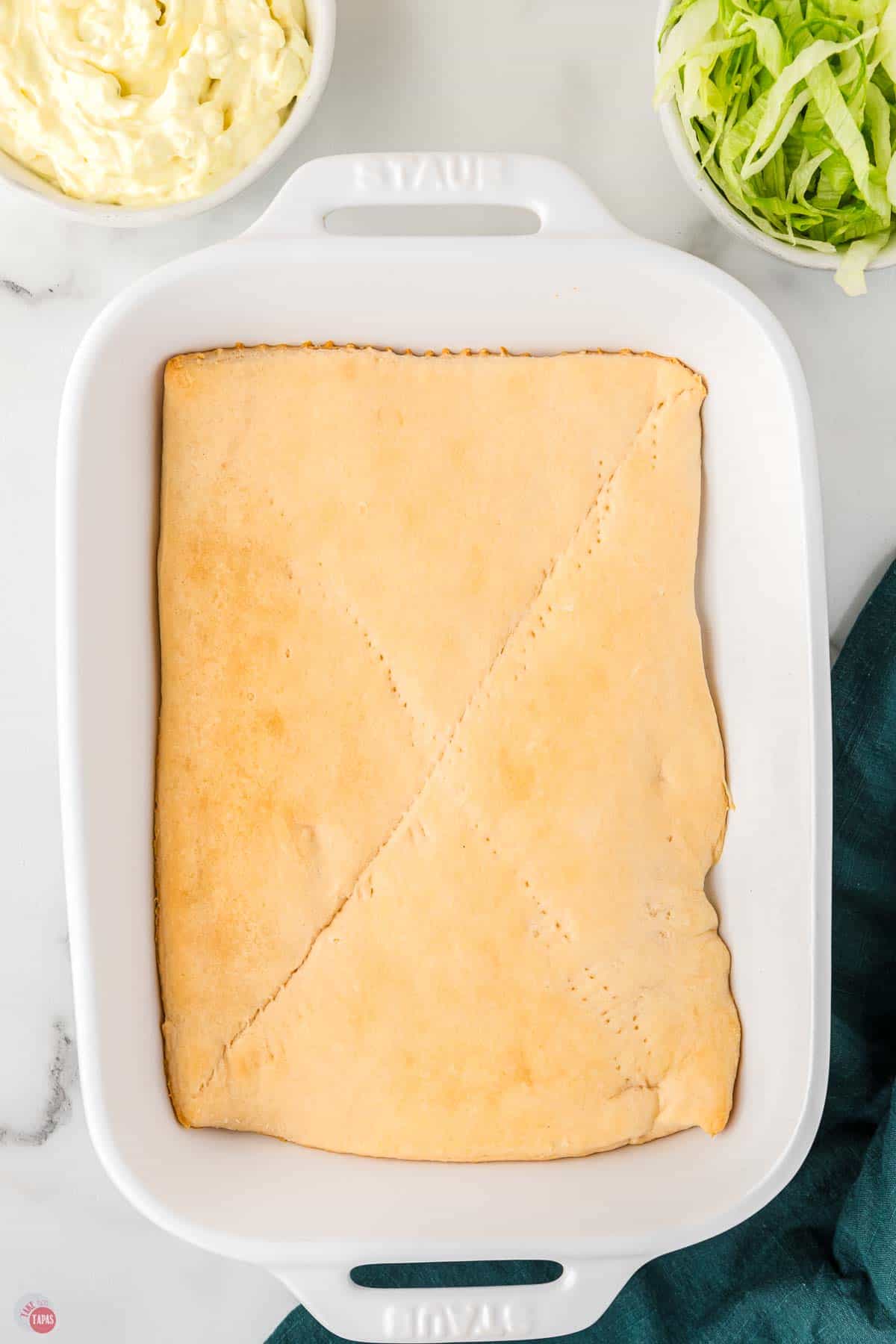 white casserole dish with crescent roll sheet baked in the bottom