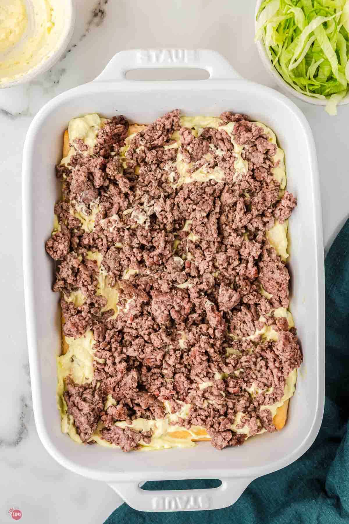 casserole dish with crust and sauce topped with ground beef