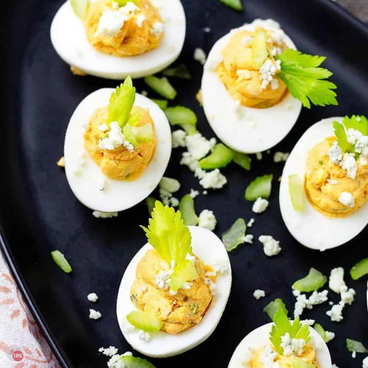 black platter with buffalo chicken deviled eggs on top