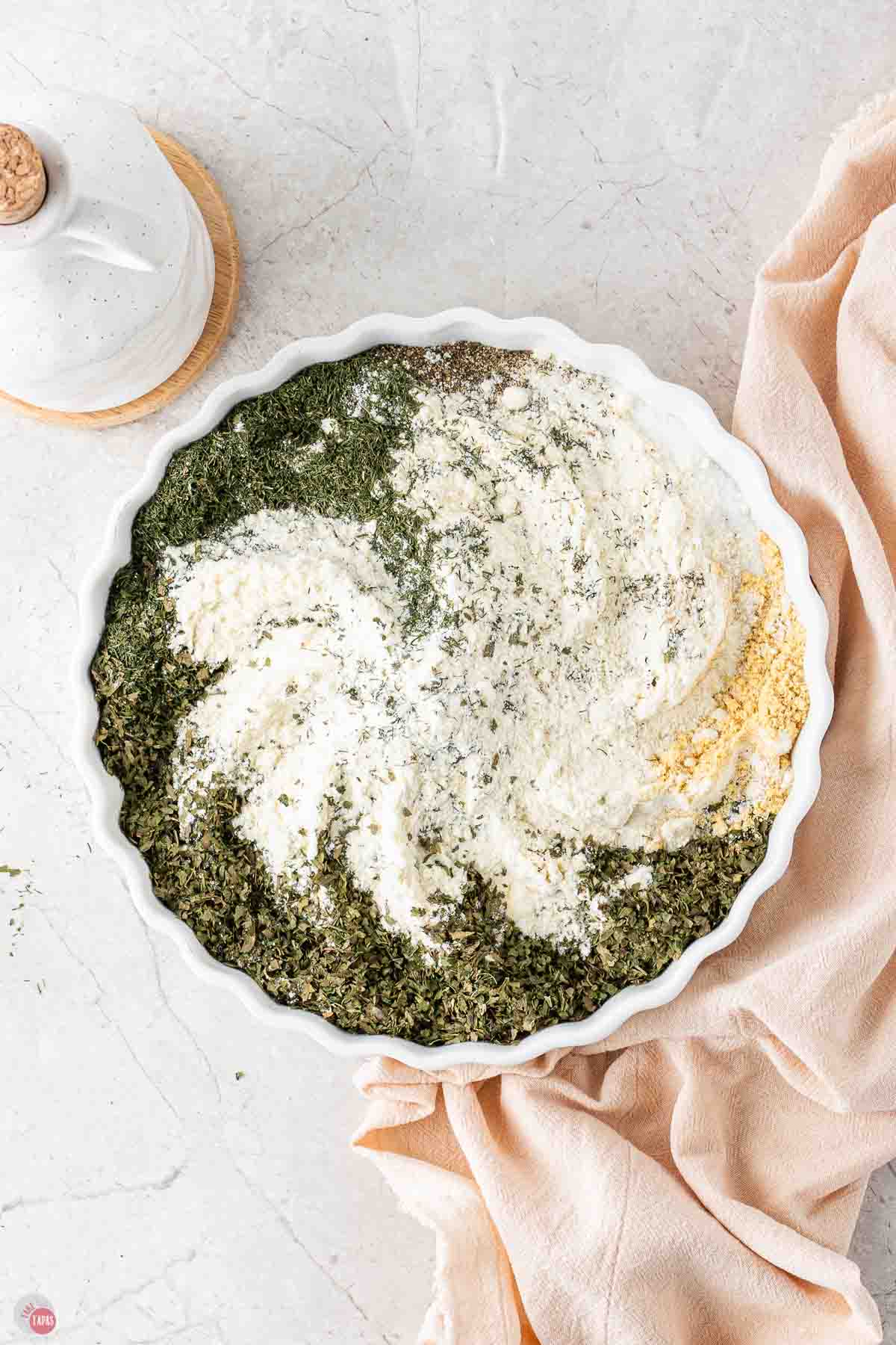 spices being whisked together in a shallow white bowl