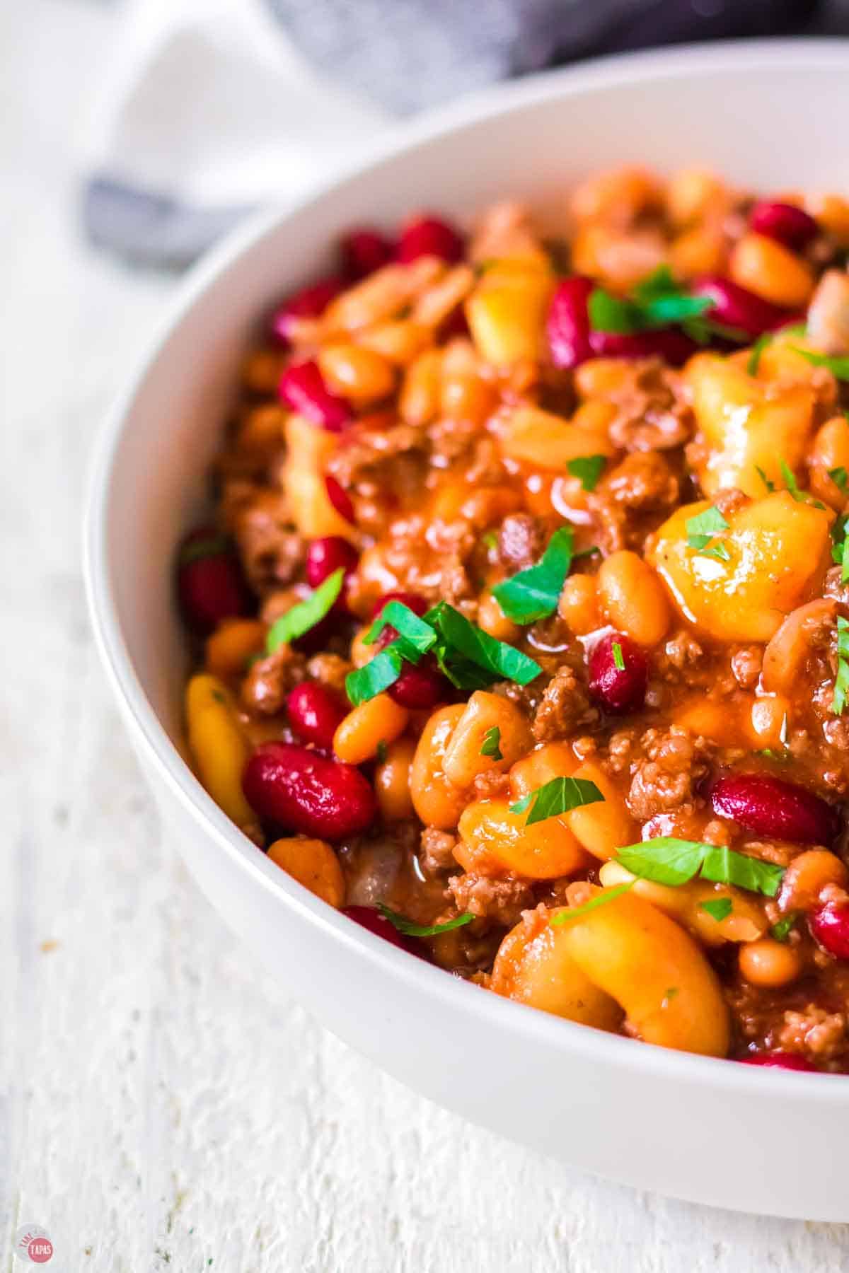 close up of white bowl full of meaty beans