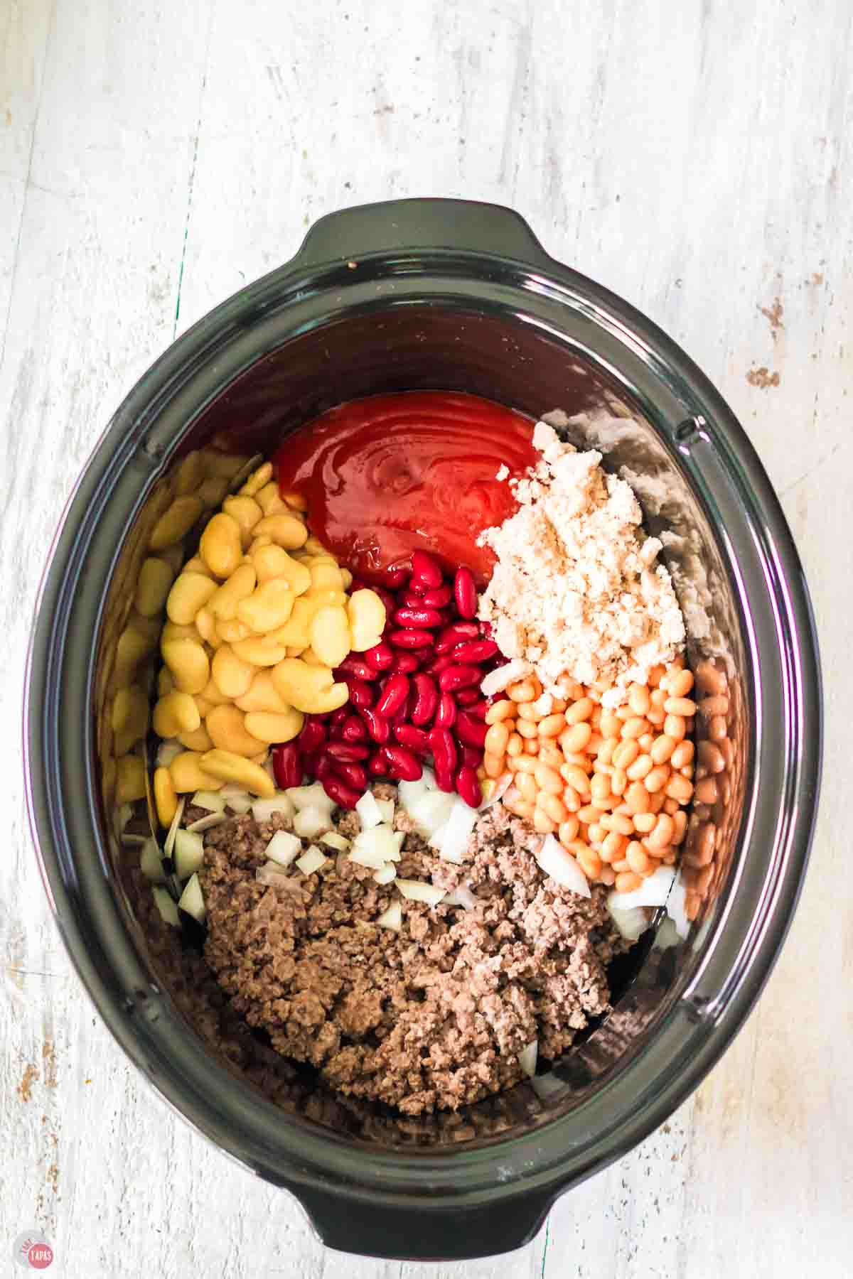 crockpot full of beans, ground beef, and onions