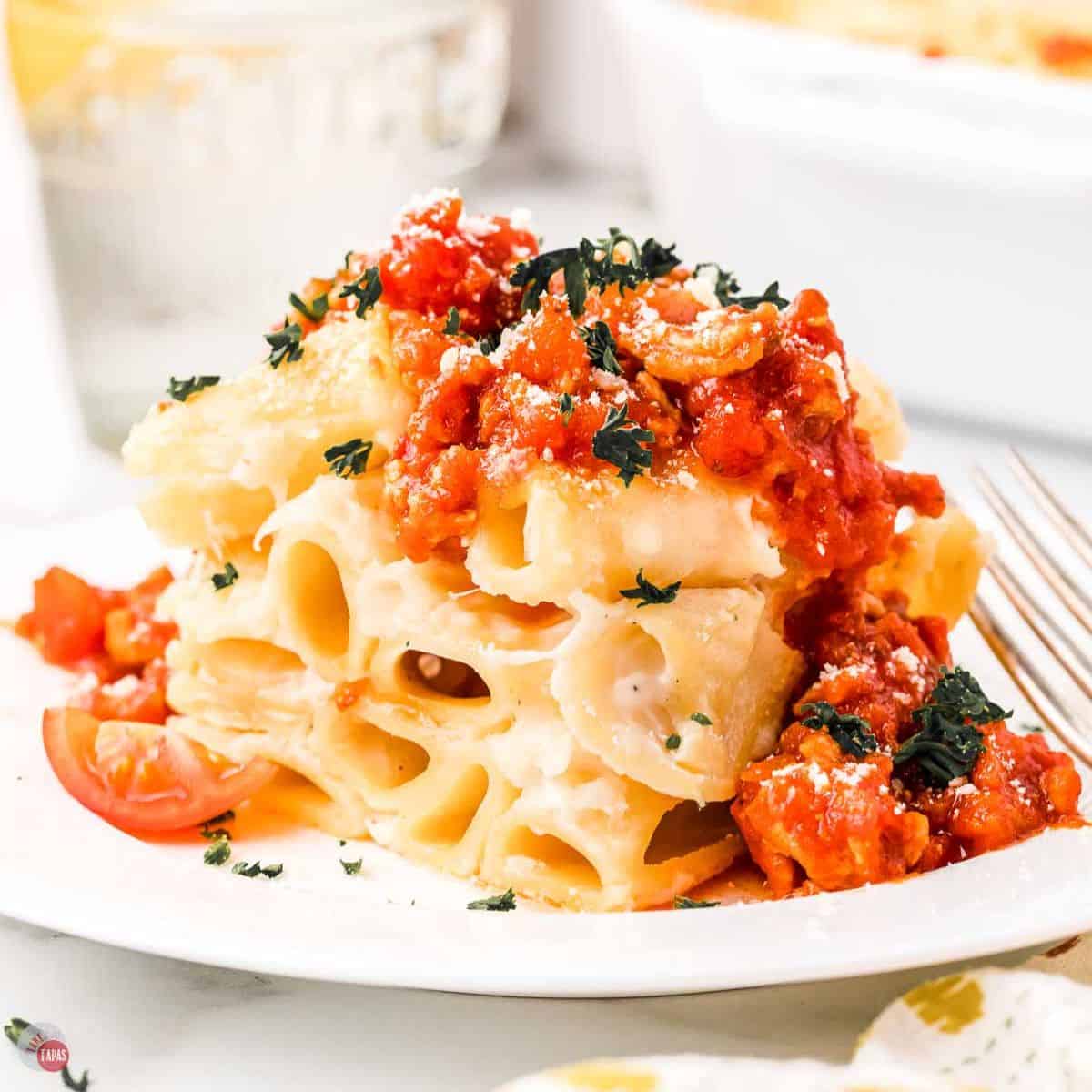 plate with slice of baked rigatoni topped with a meat sauce