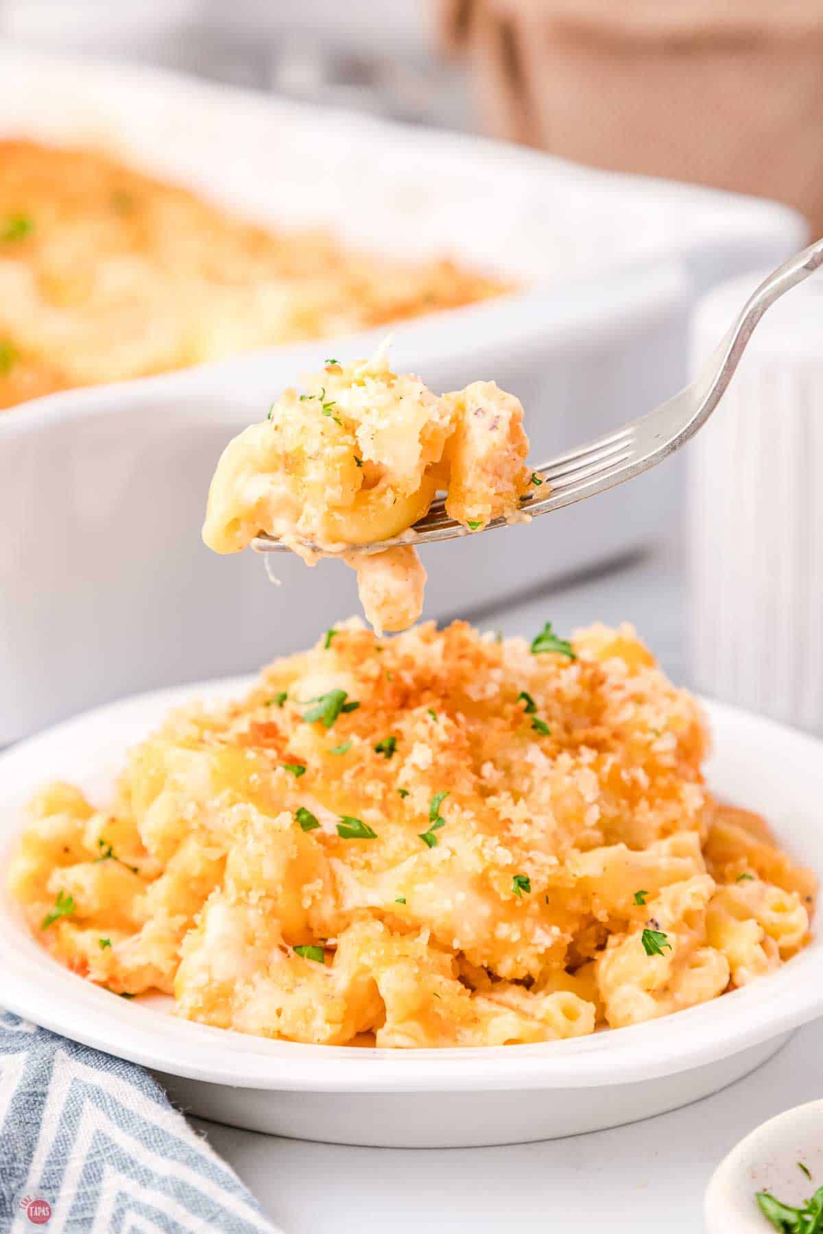 fork with bite of macaroni and cheese over a bowl