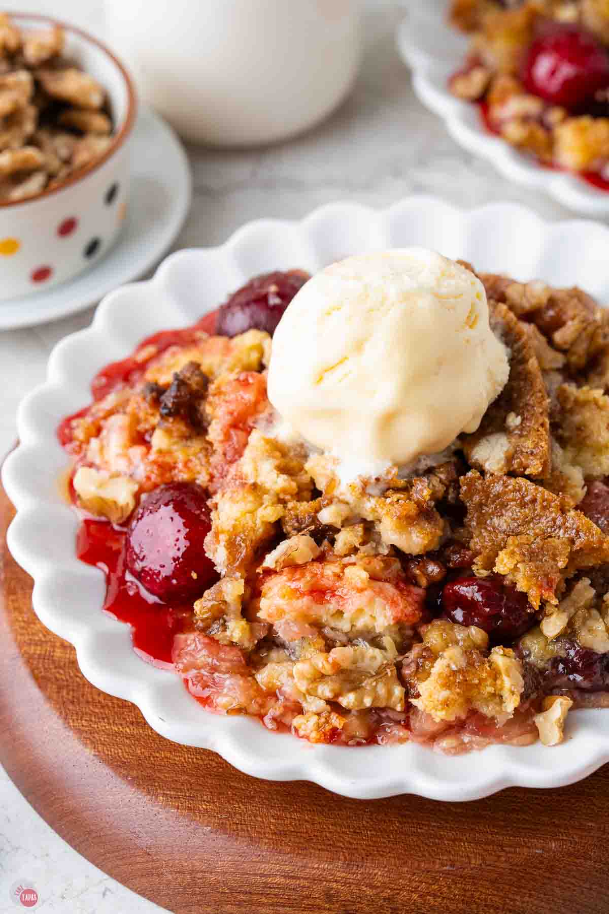 cherry dump cake on a plate with a scoop of vanilla ice cream