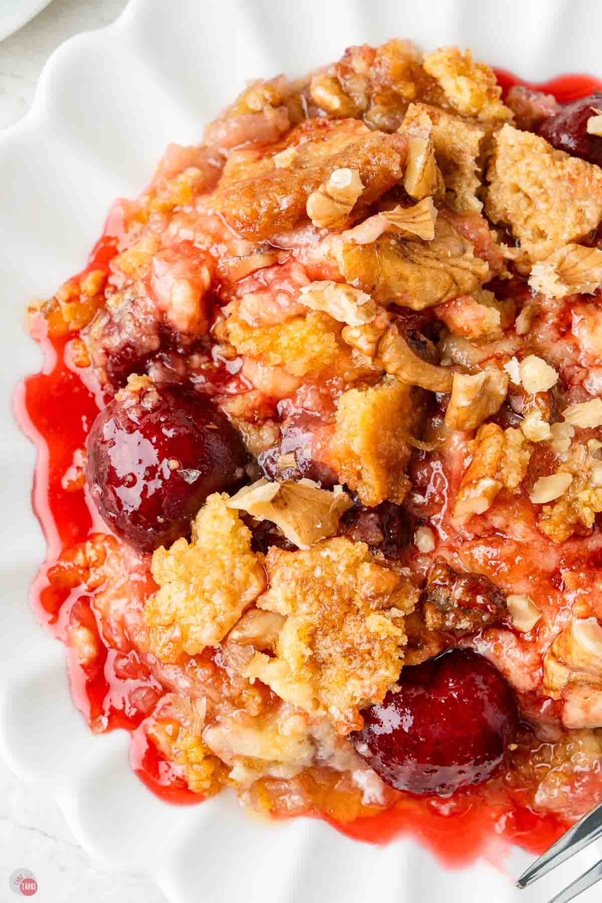 close up of cherry dump cake on a white plate