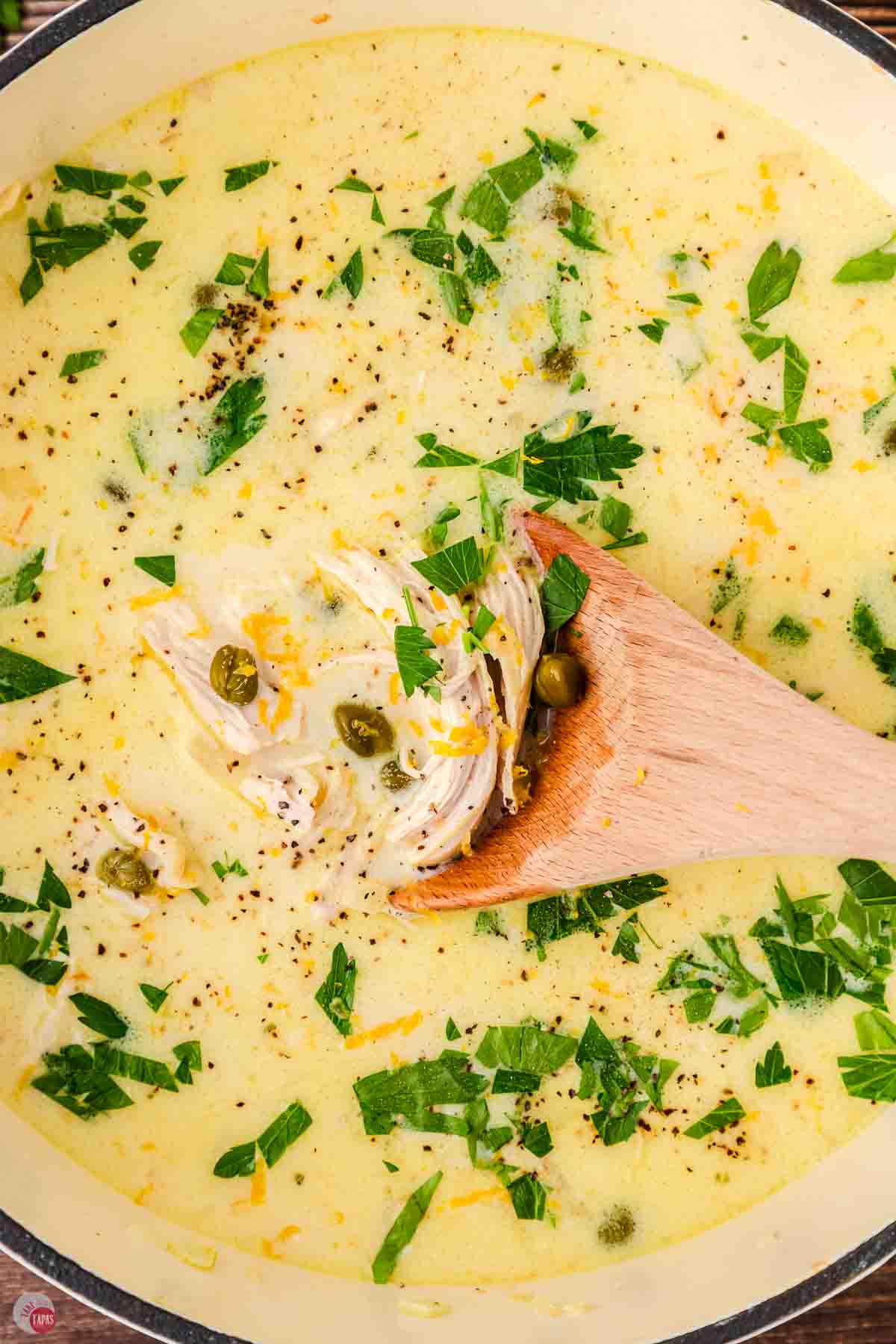 close up of chicken soup and a wood spoon