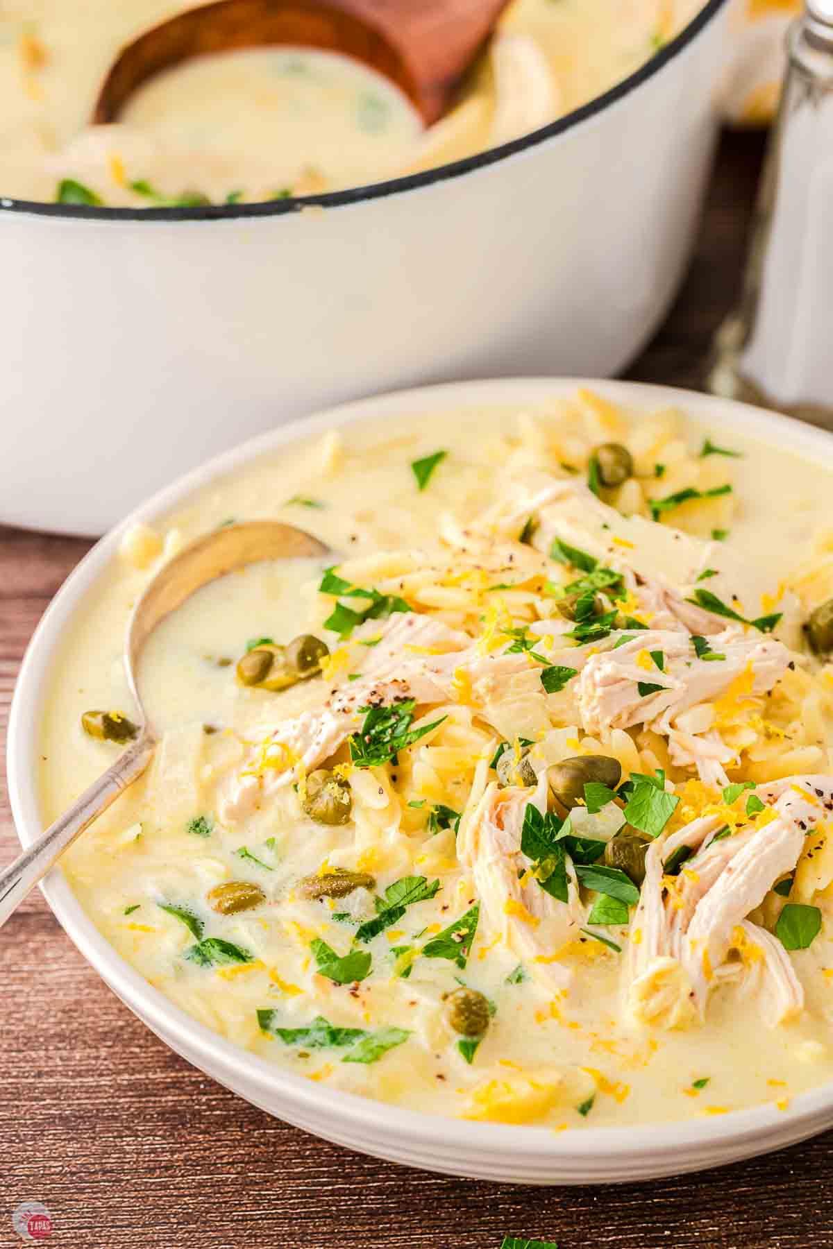close up of pot of soup with chicken and capers