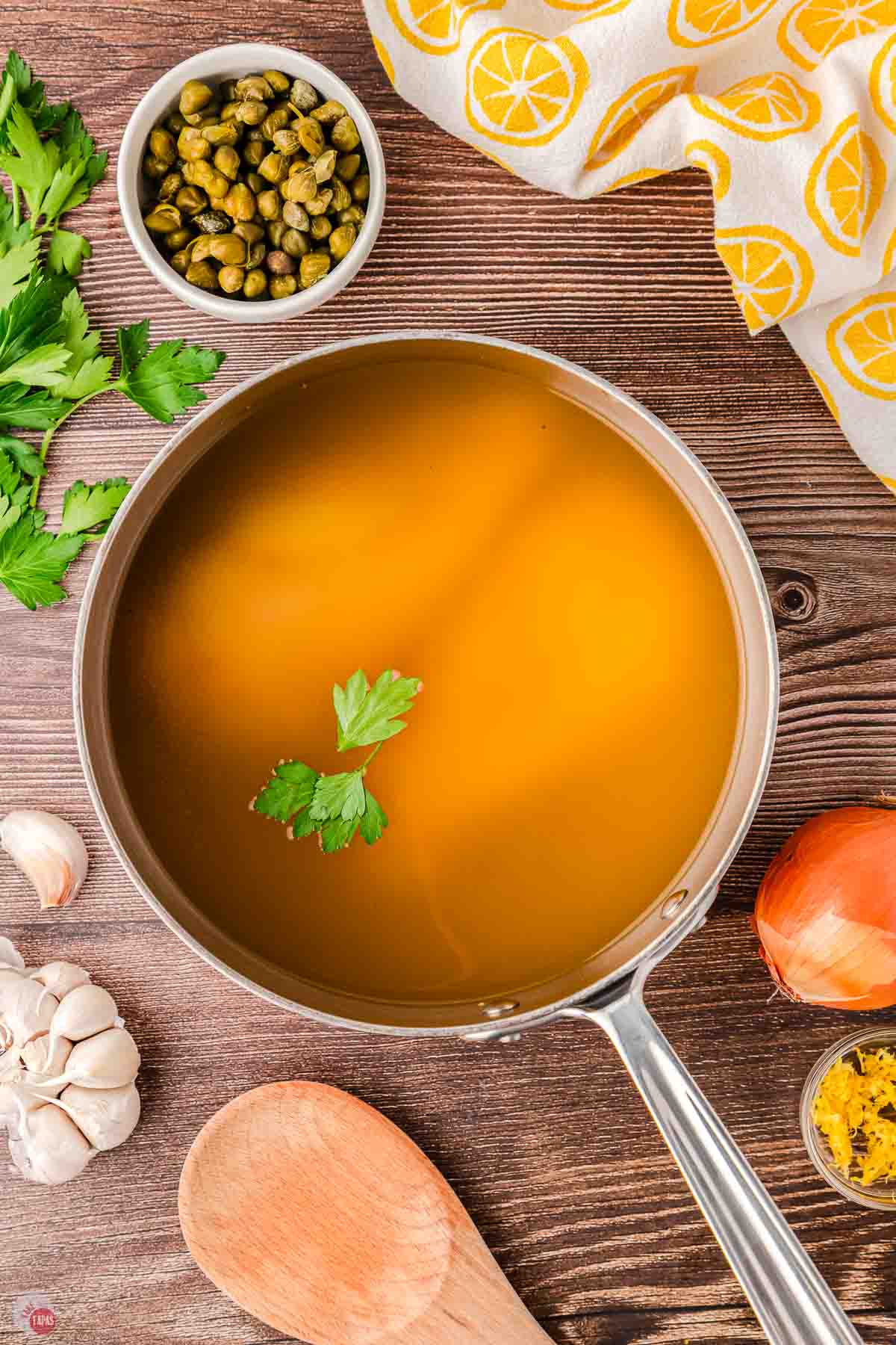 two chicken breasts and broth in a small pot
