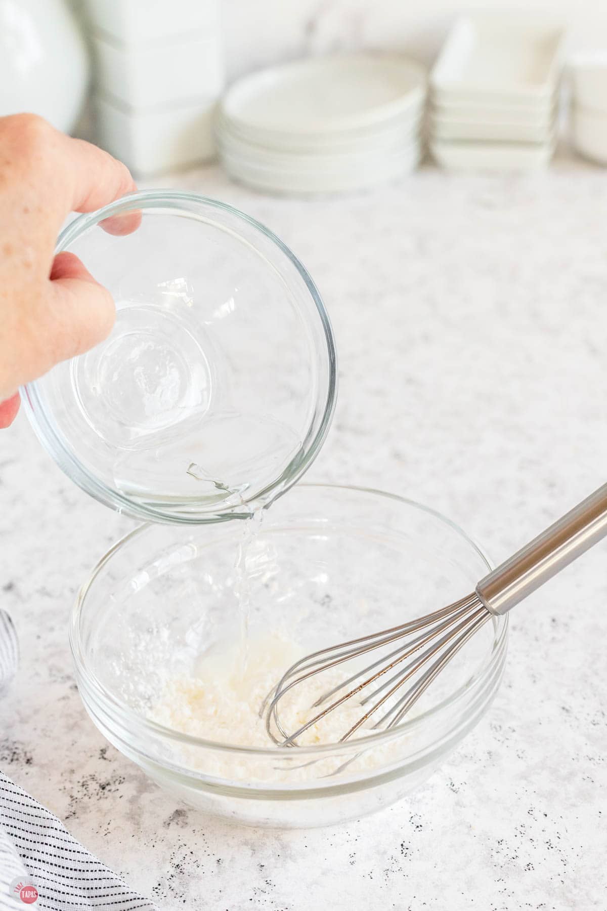 bowl of cornstarch with water being poured into it