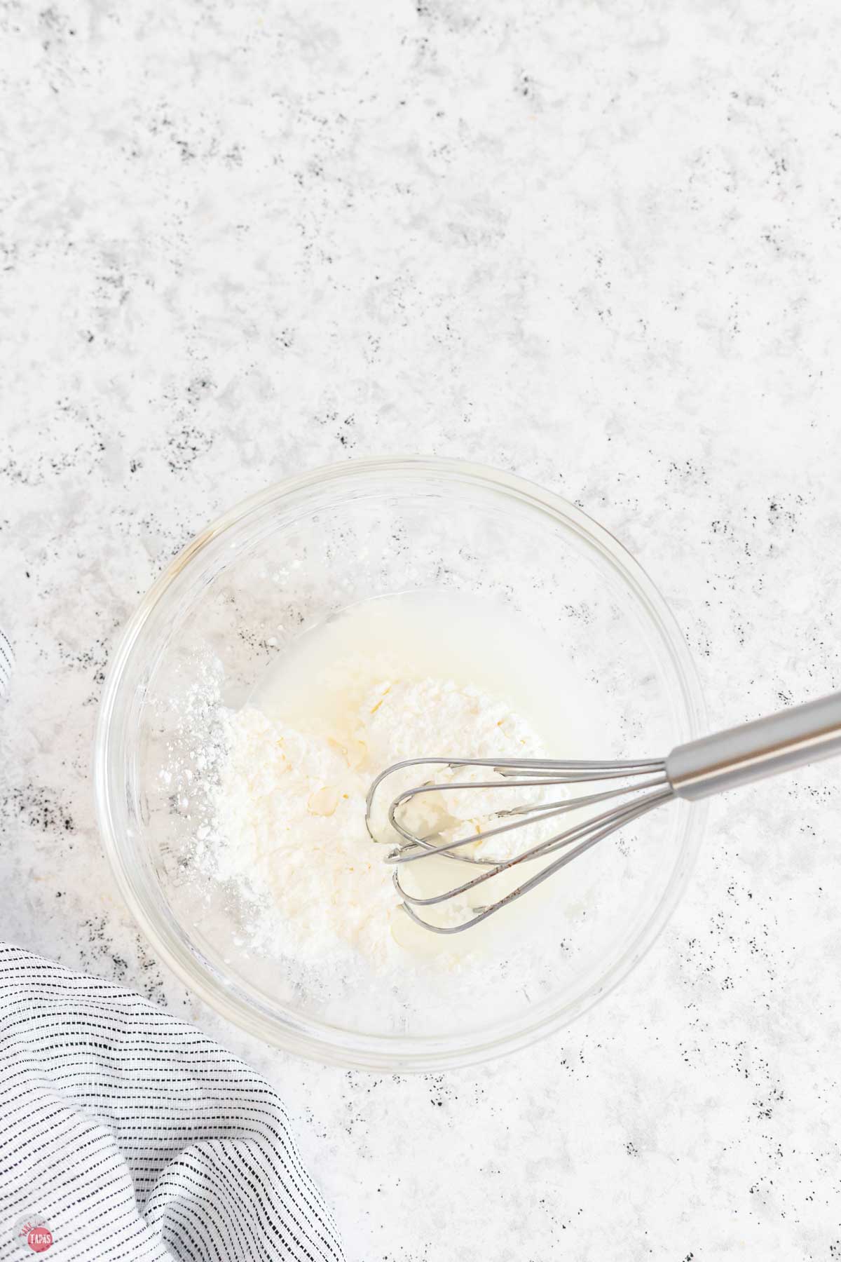 clear bowl with a whisk making a slurry