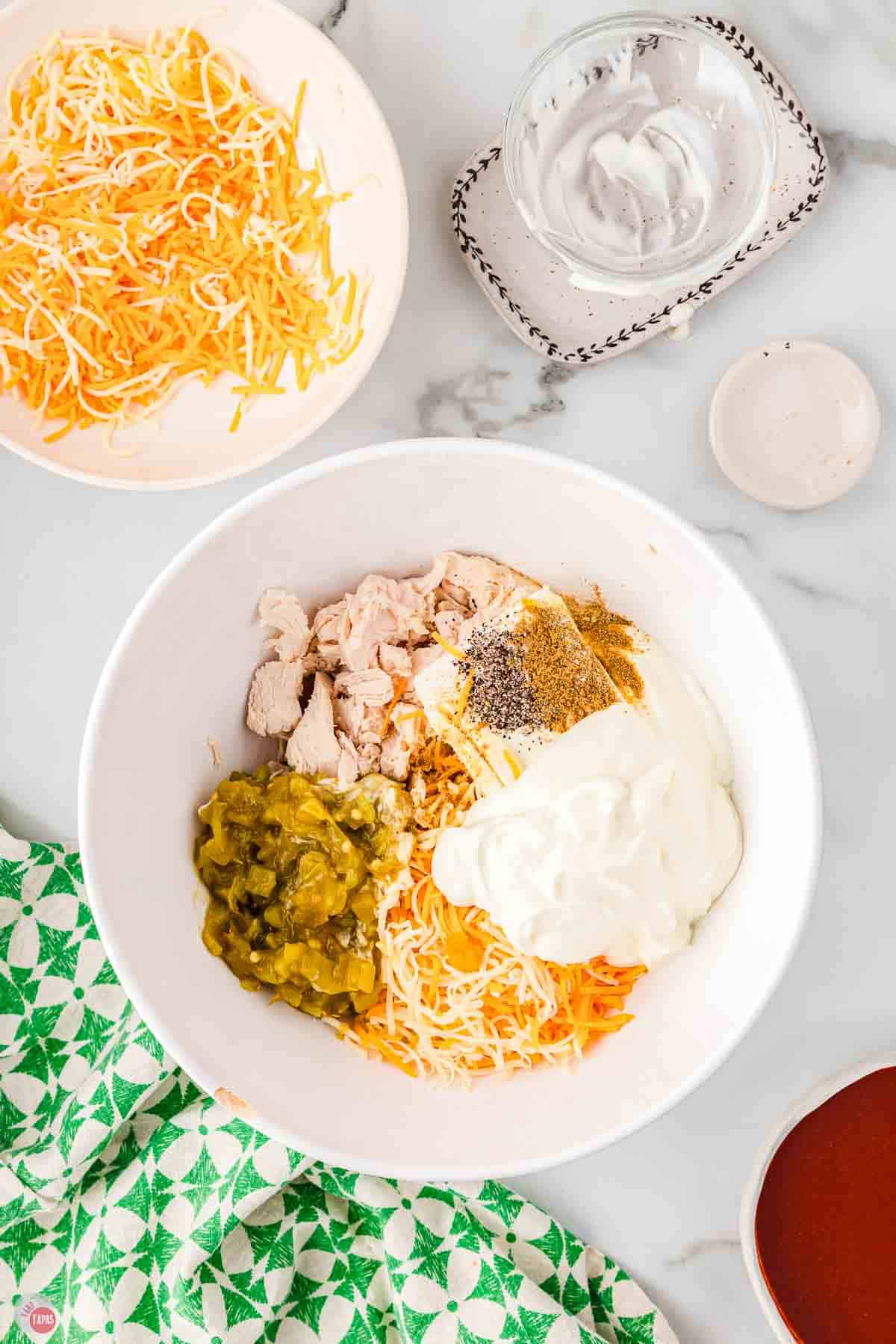 chicken, cheese, and green chilies in a white mixing bowl