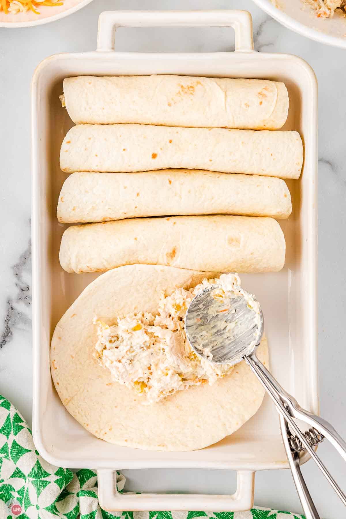 plain enchiladas lined up in a casserole dish
