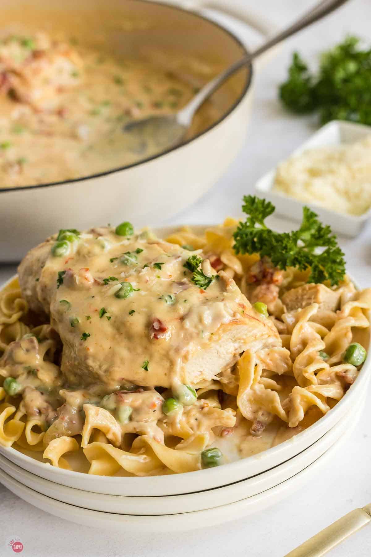 close up of chicken on egg noodles topped with a creamy sauce