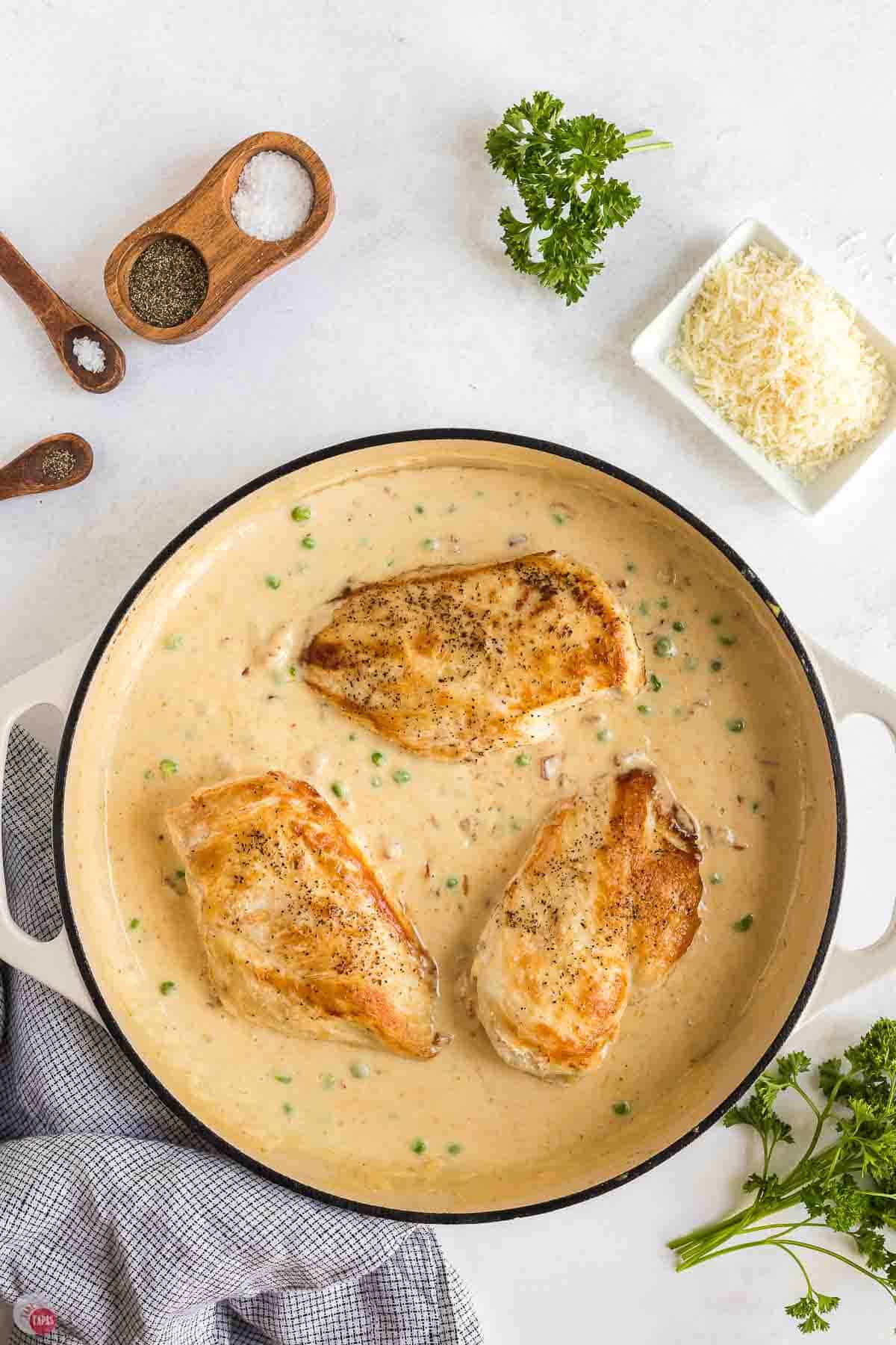 seared chicken breasts sitting in a creamy sauce