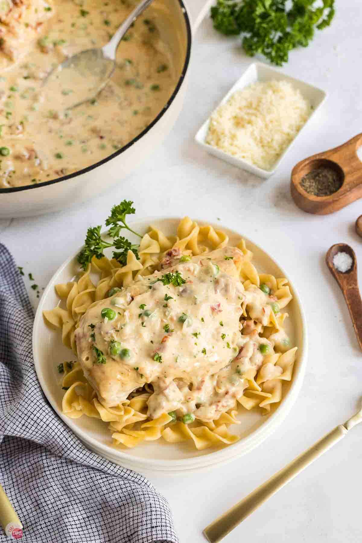 shallow bowl with egg noodles and a piece of creamy chicken