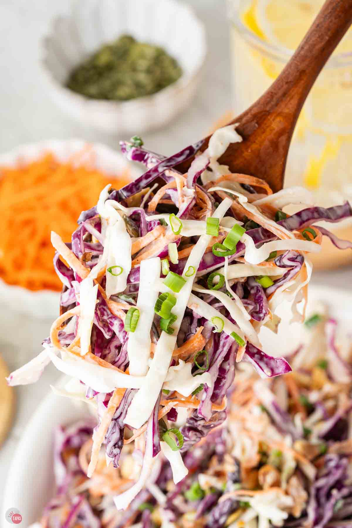 big wood spoon with a scoop of cabbage coleslaw