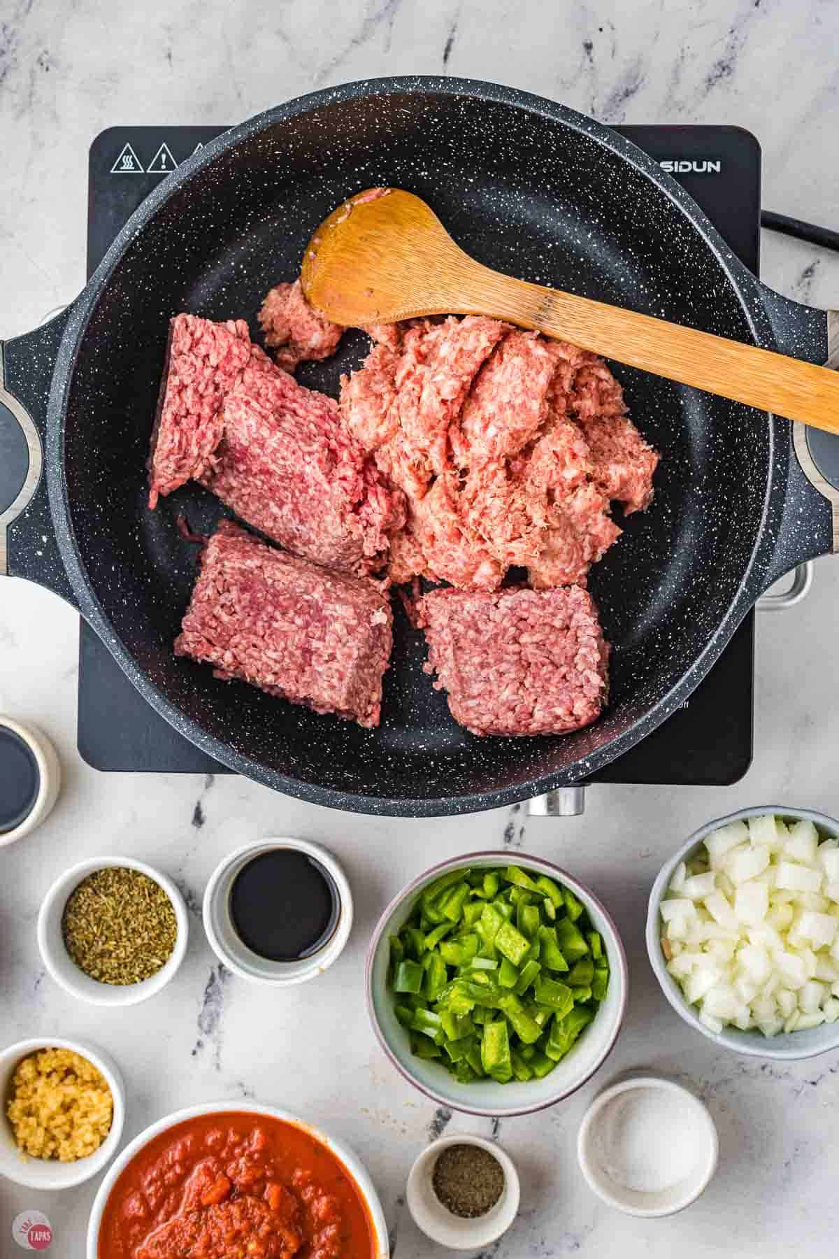 ground meat cooking in a black skillet