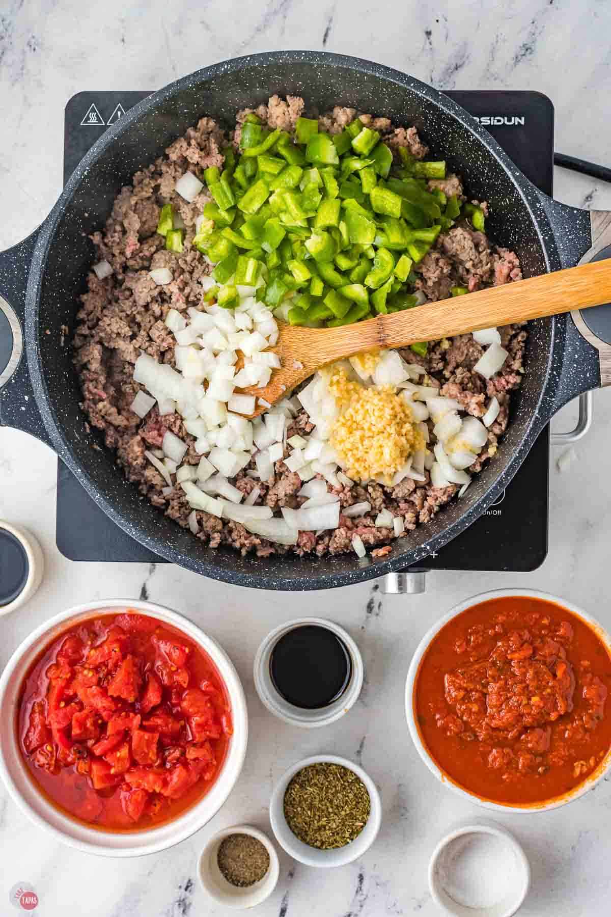 cooked ground beef in a skillet with onions and bell peppers