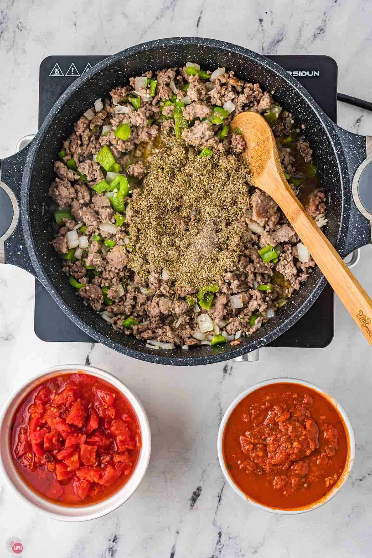 ground beef, onions, and peppers cooking in a skillet