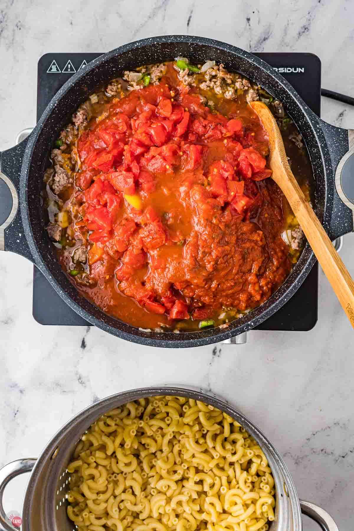 tomato sauce being stirred into a skillet