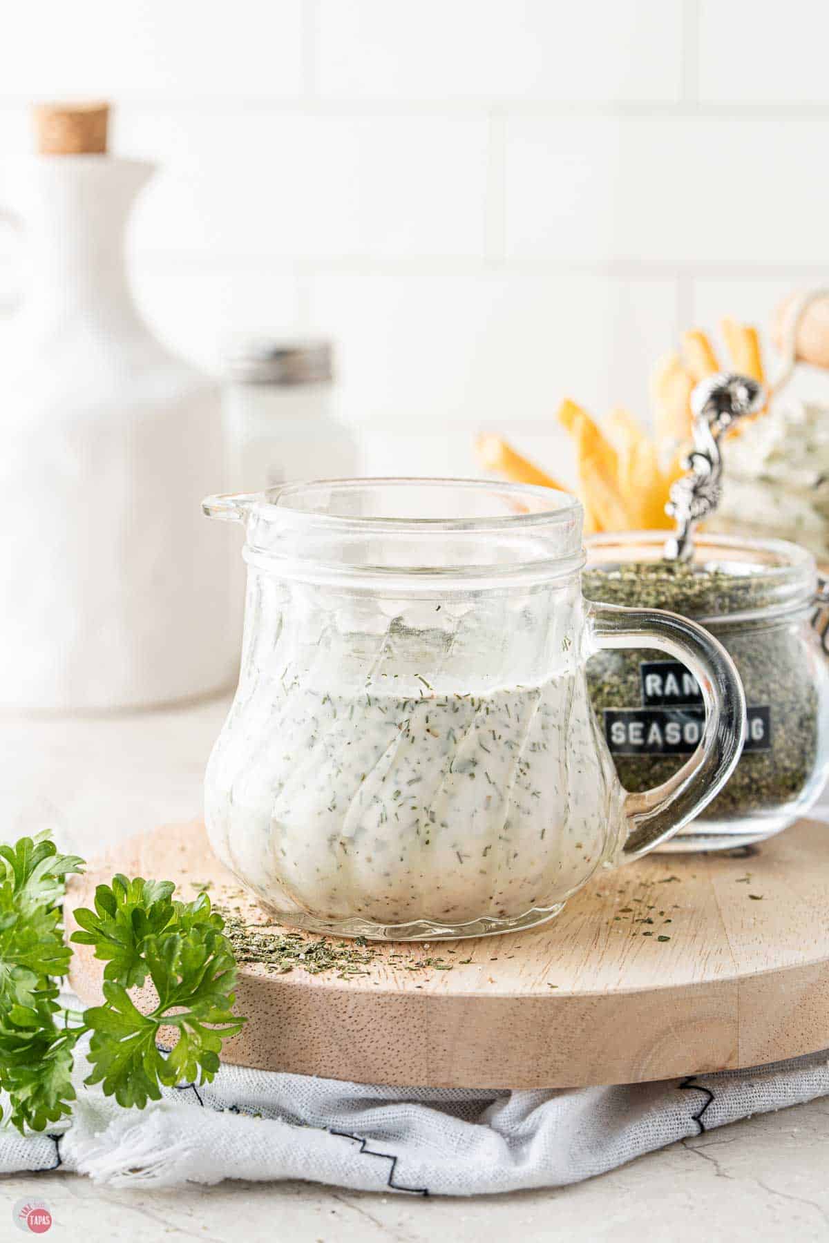 small jar with a handle full of ranch dressing on a wood board