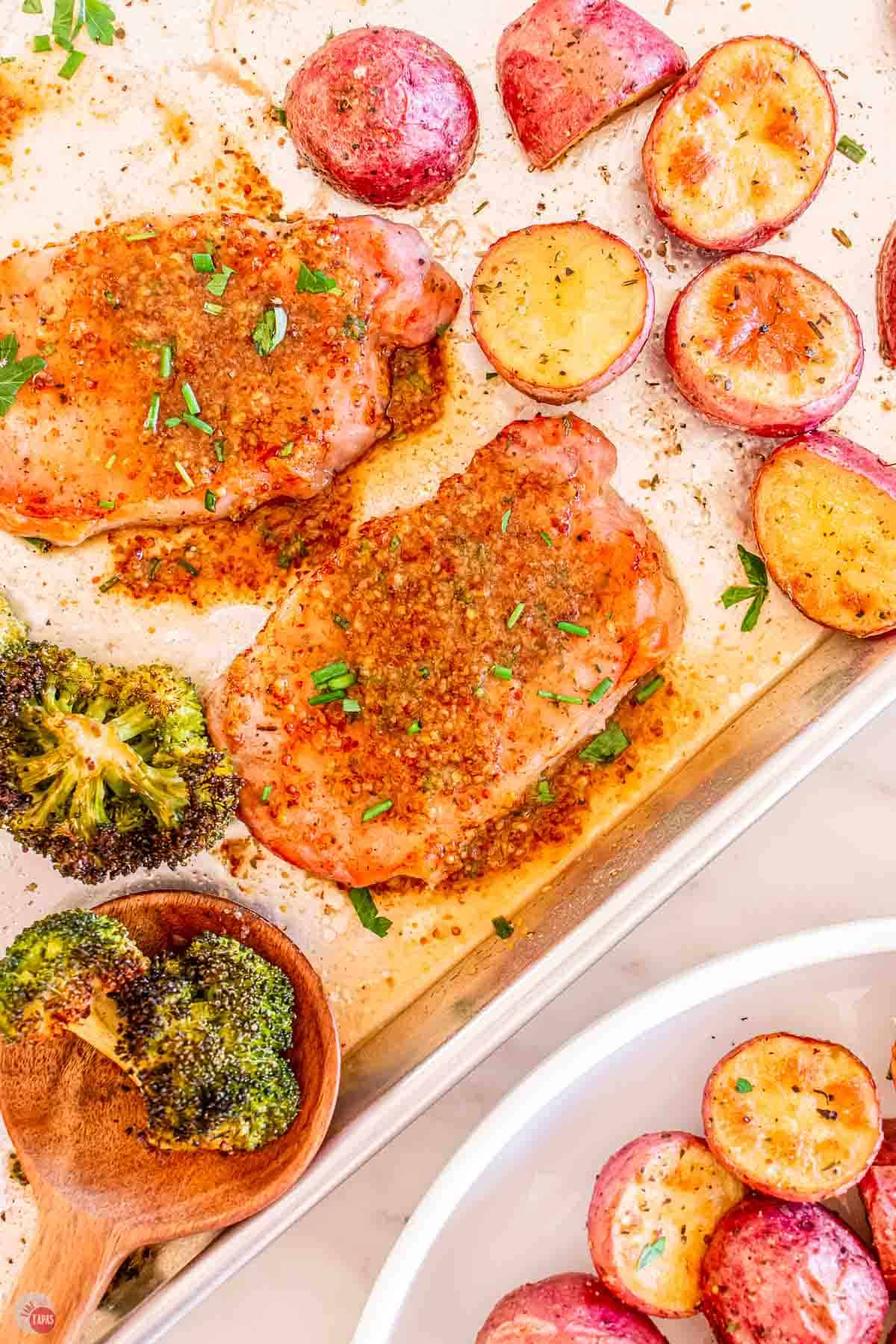 pork chops and potatoes on a sheet pan