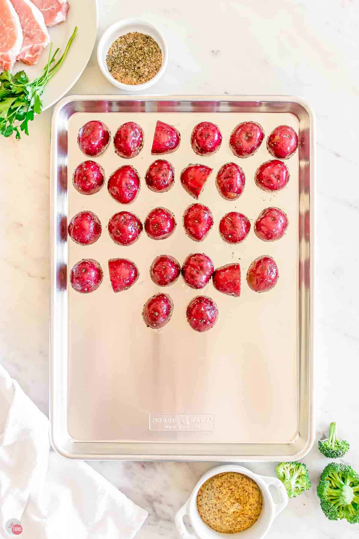 baking sheet with halved red potatoes on it