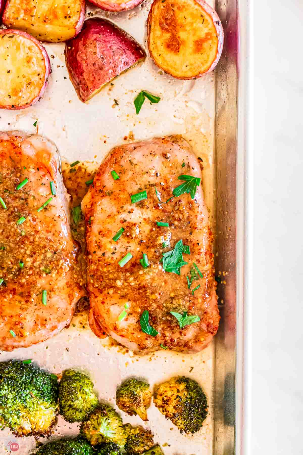 close up of pork chop on a silver baking sheet