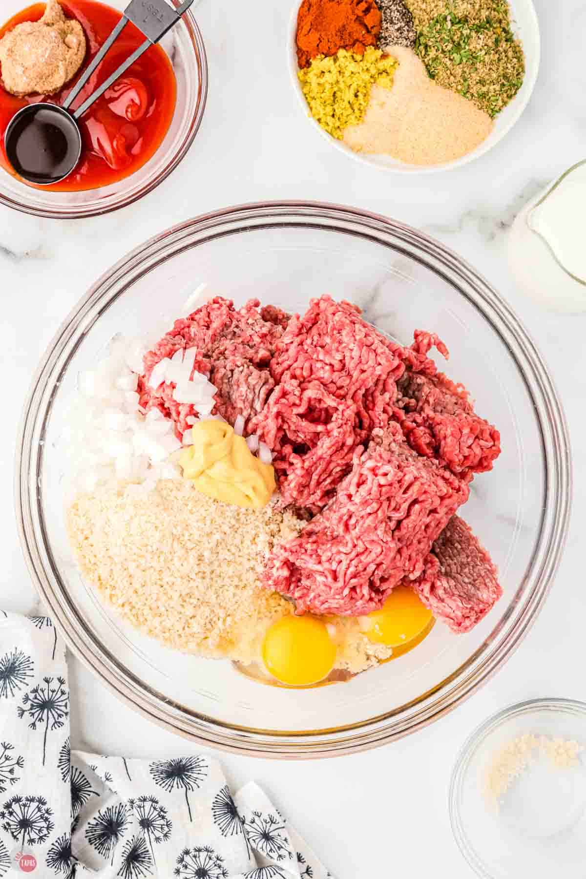 ground beef, breadcrumbs, and eggs in a clear mixing bowl