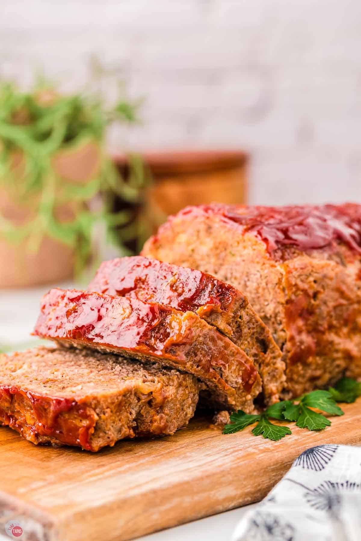 wood board with sliced meatloaf on top