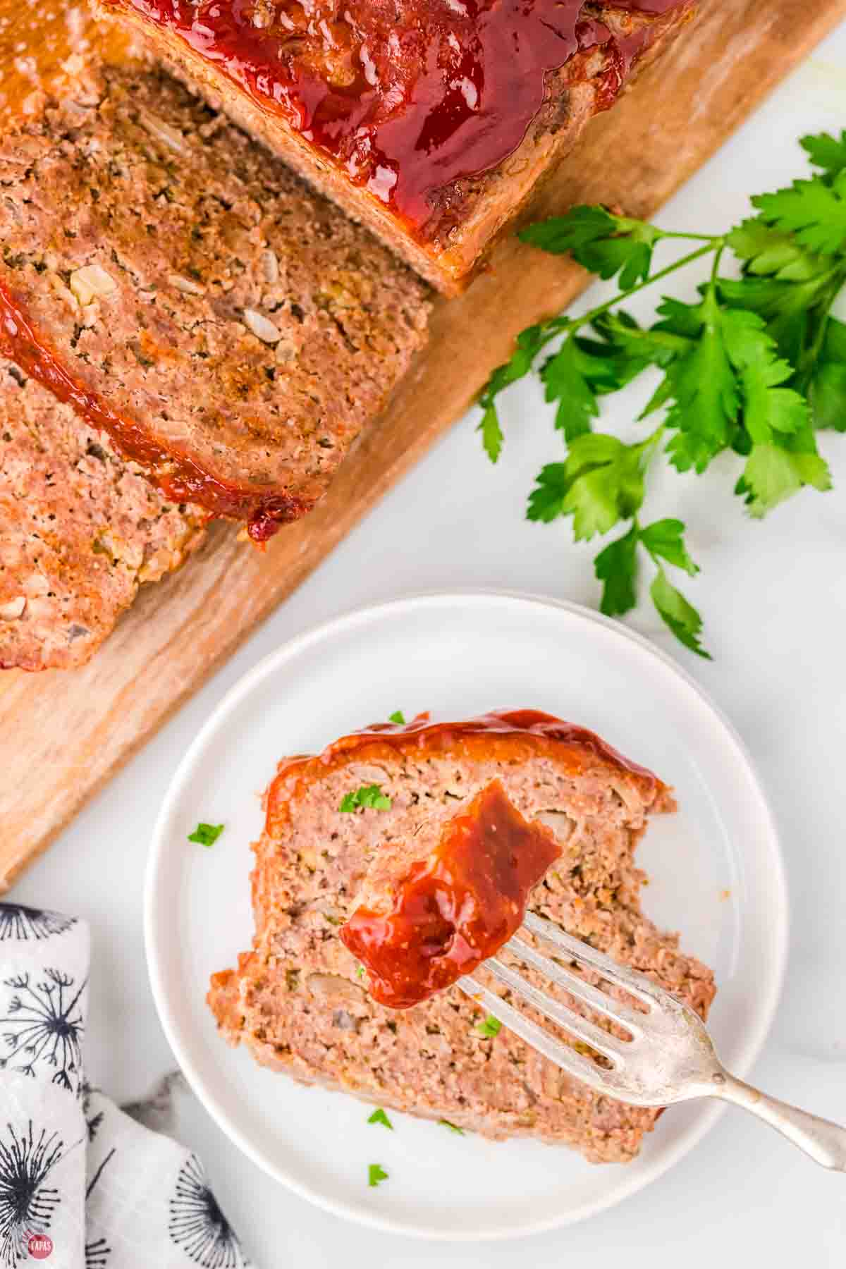 plate with slice of meatloaf and a fork holding a bite