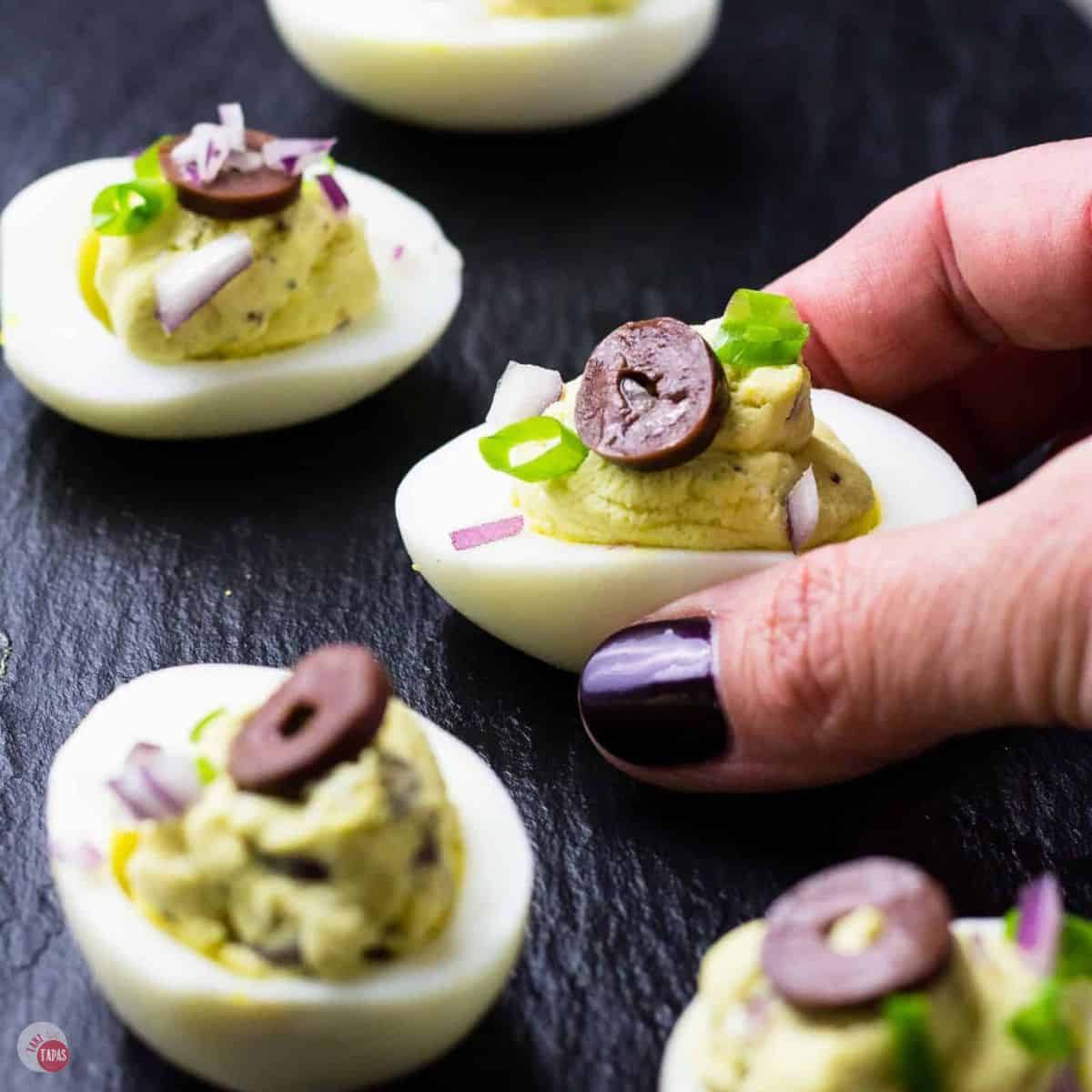 Mediterranean deviled eggs on a black slate platter