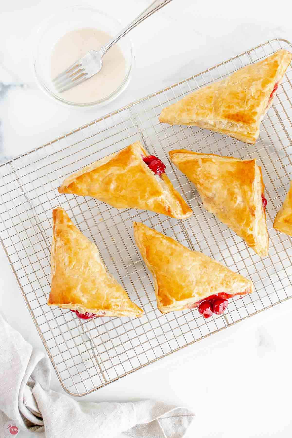 baked cherry turnovers cooling on a wire rack