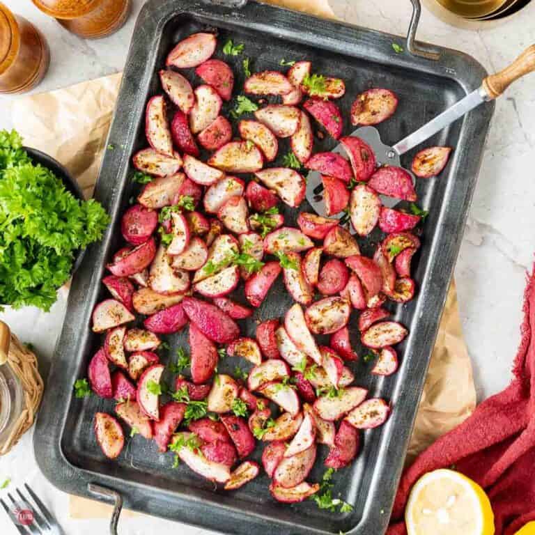 baking sheet topped with roasted radishes and a spatula