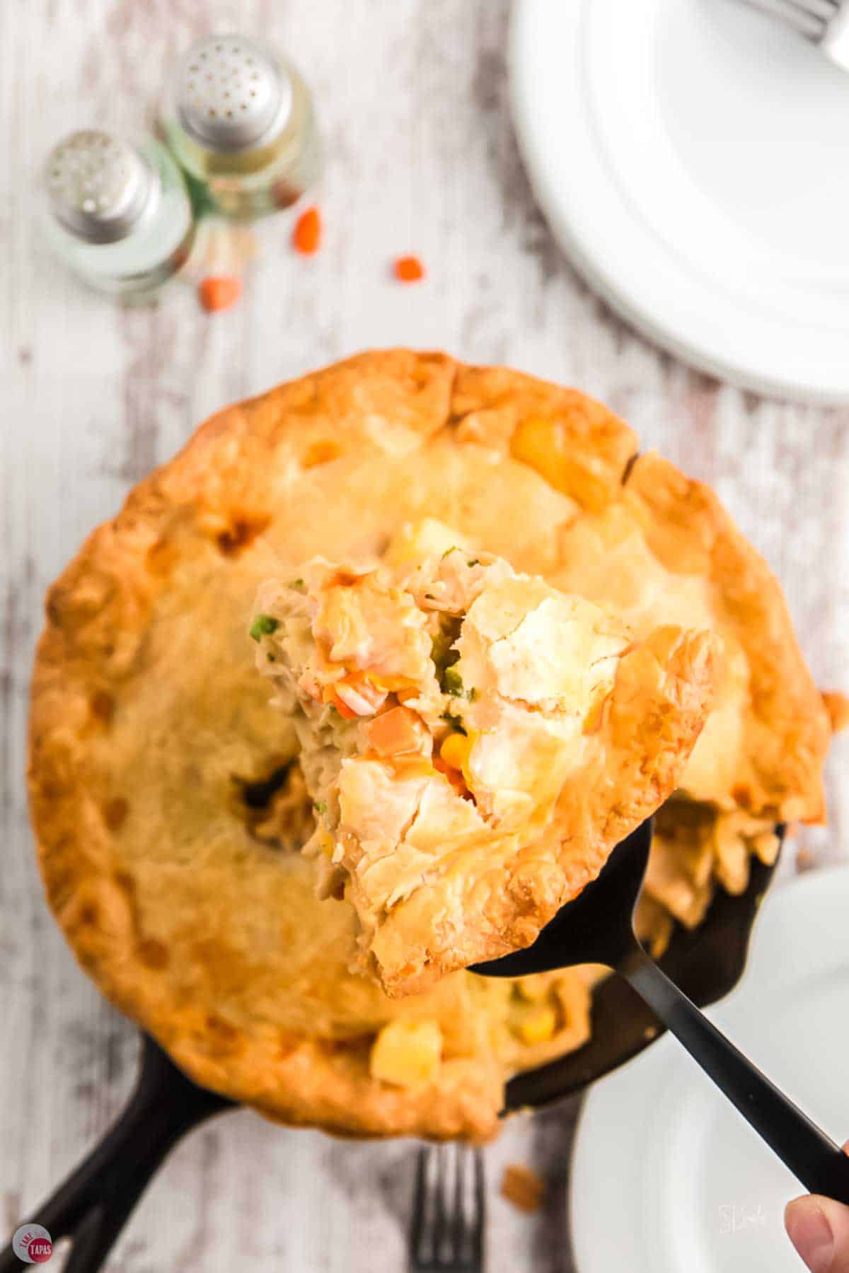 cast iron skillet chicken pot pie with a wedge bring removed with a spatula