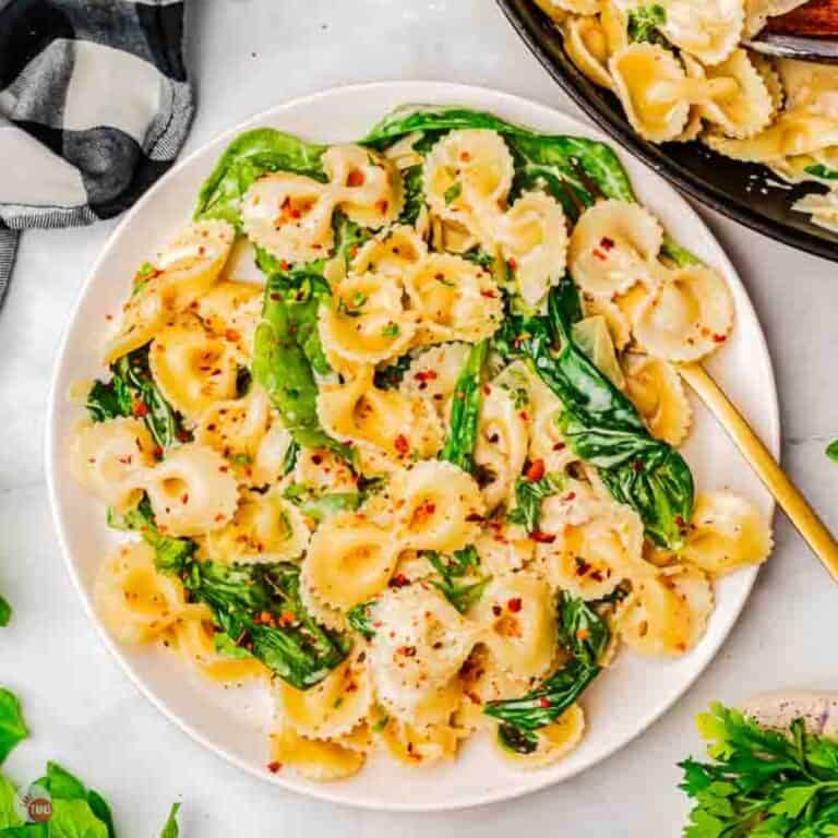 plate of sour cream pasta with spinach and a gold fork