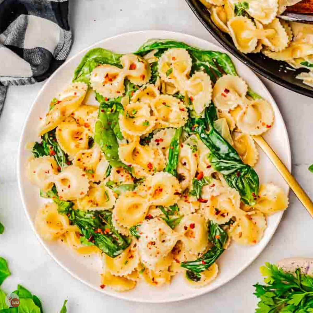 plate of sour cream pasta with spinach and a gold fork