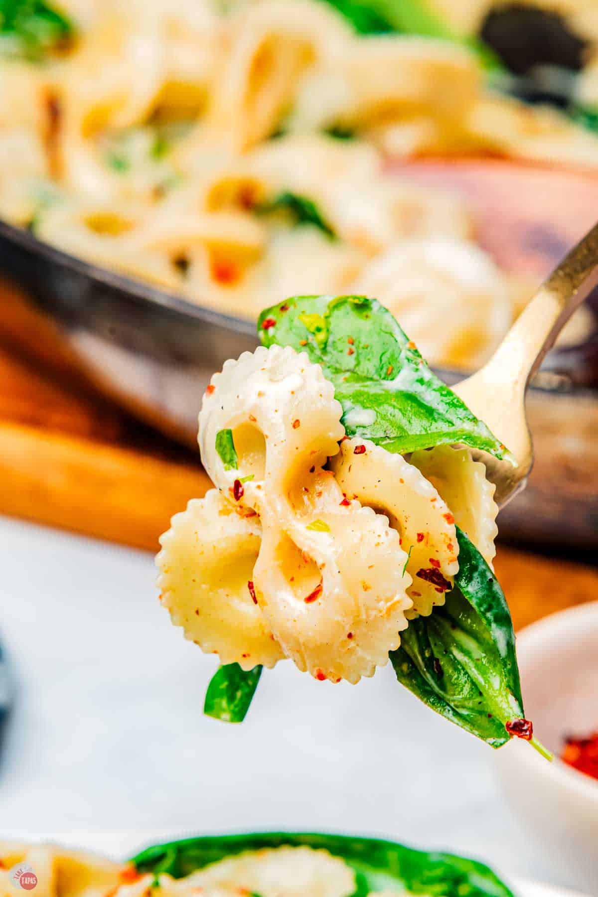 close up of fork with pasta and spinach on it