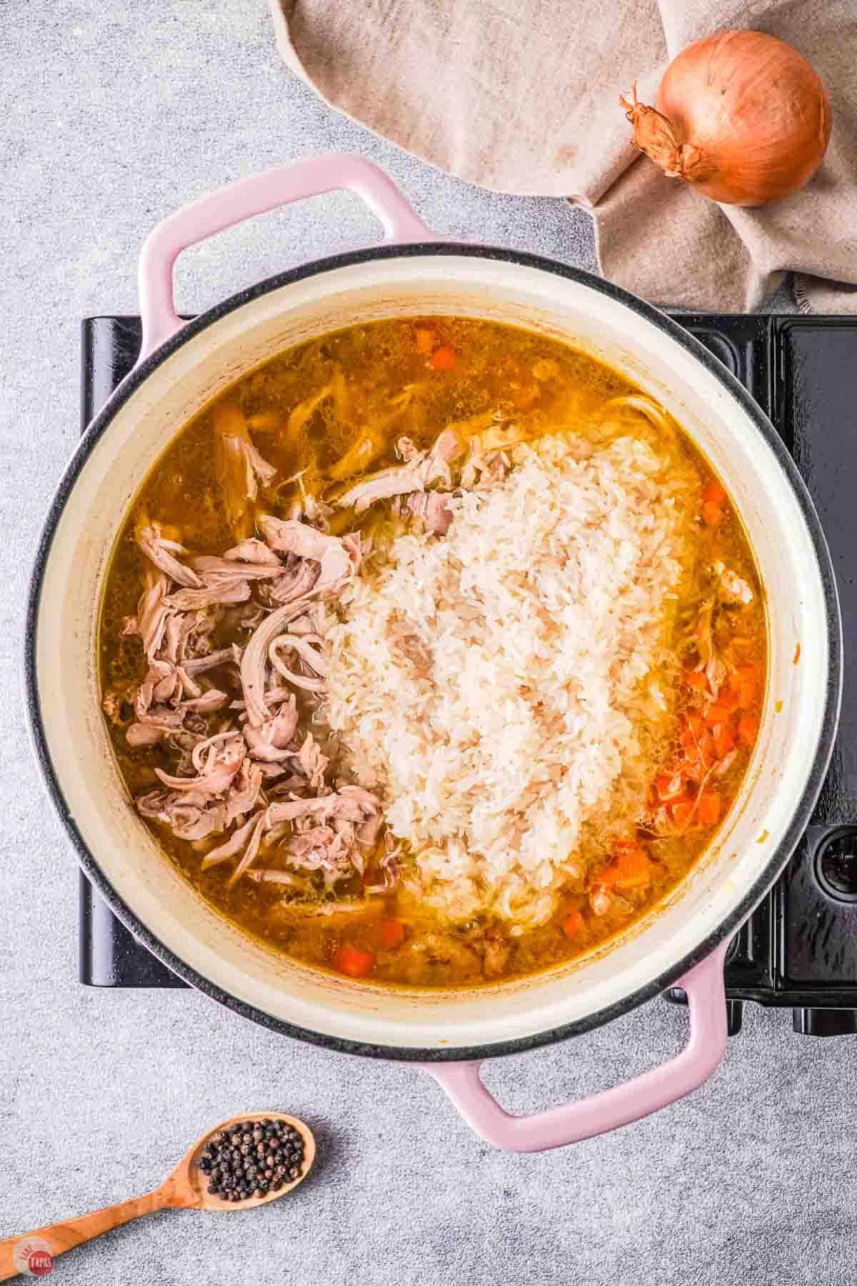 pot of soup with rice and shredded chicken