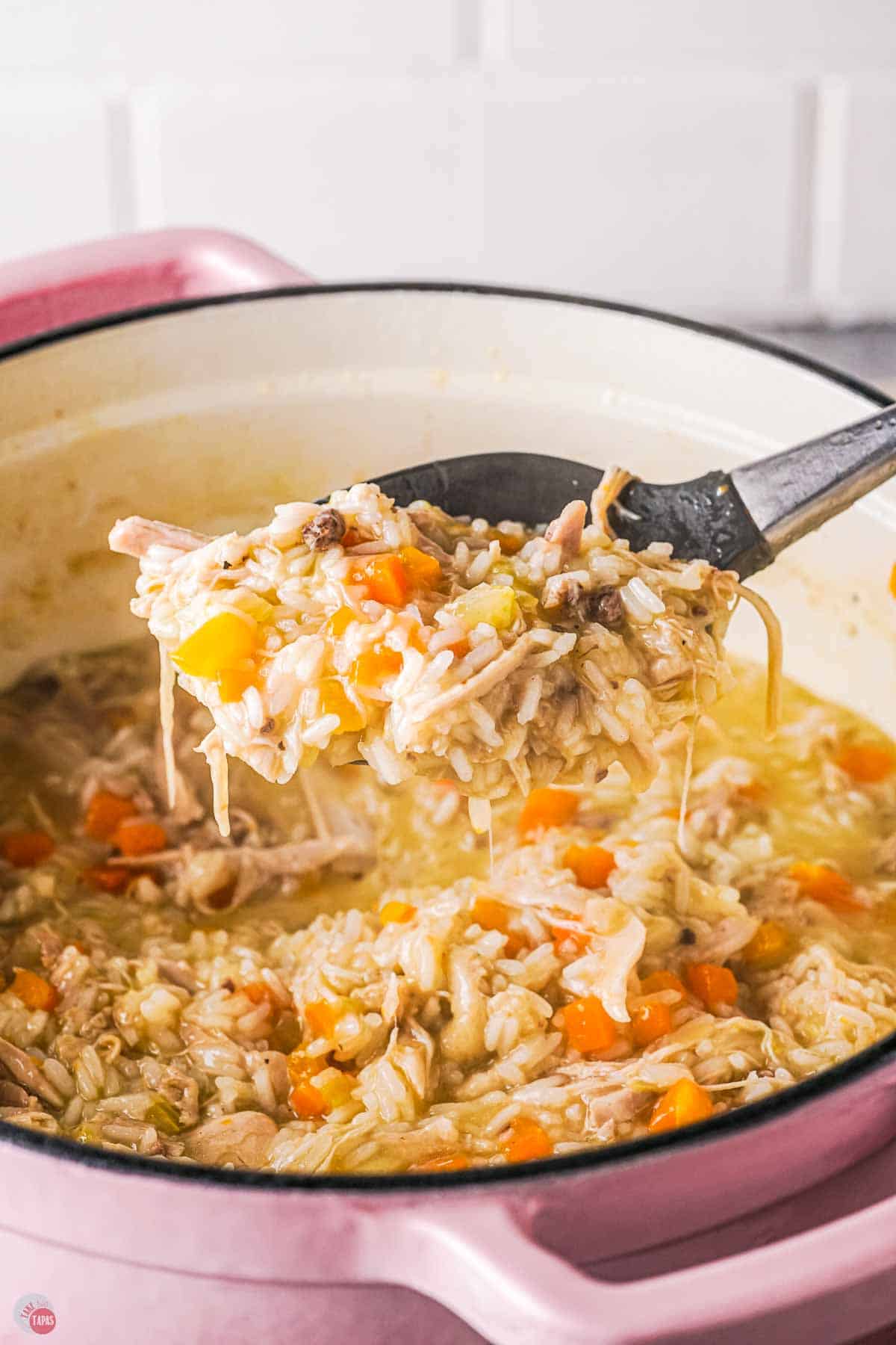 spoon scooping chicken and rice out of a pot
