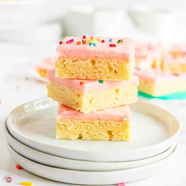 stack of sugar cookie bars on a stack of white plates
