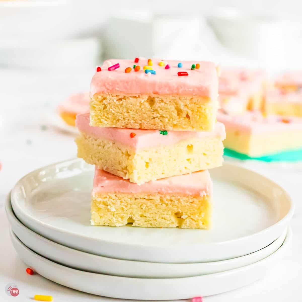 stack of sugar cookie bars on a stack of white plates