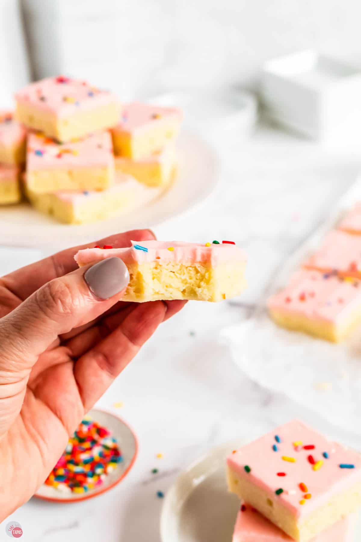 hand holding a cookie bar with a bite missing