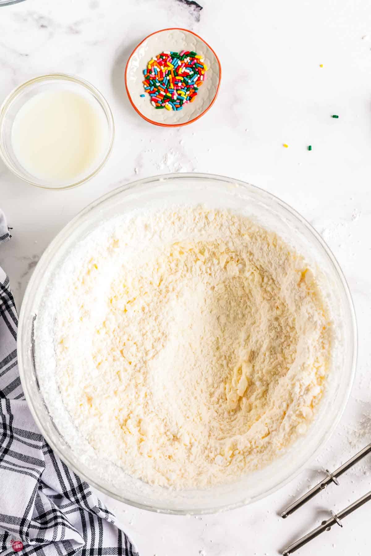 sugar cookie dough being mixed in a clear bowl
