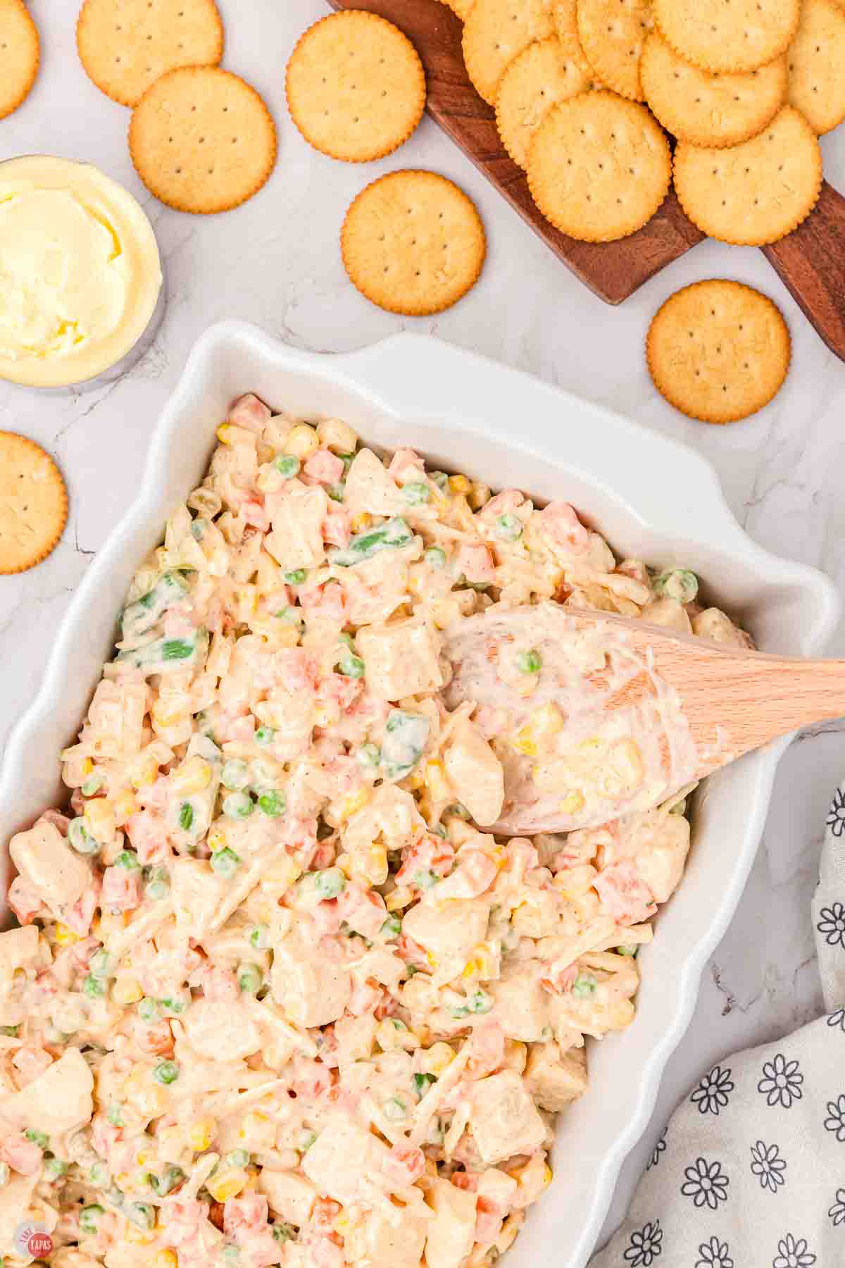 creamy vegetable being spread into a white casserole dish