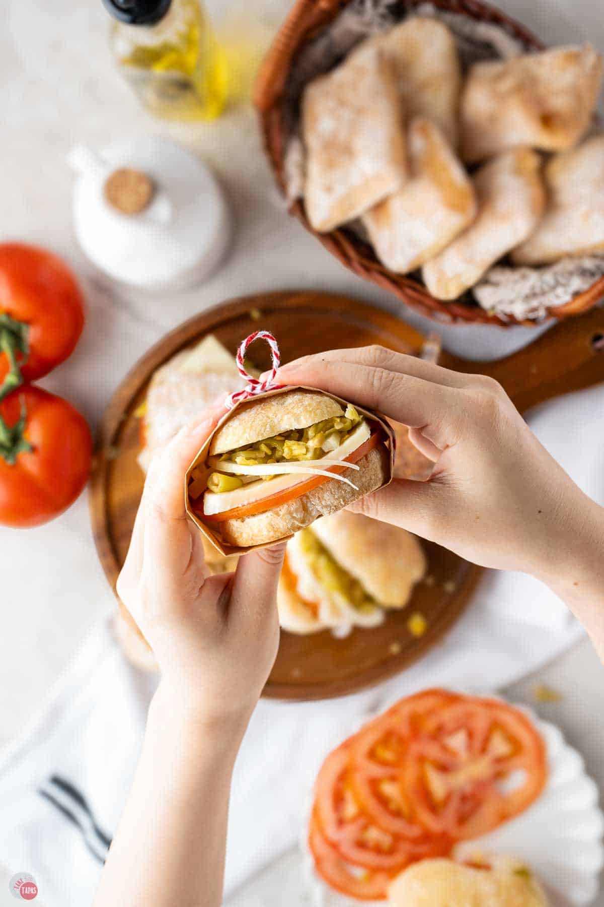 hand holding a wrapped sandwich
