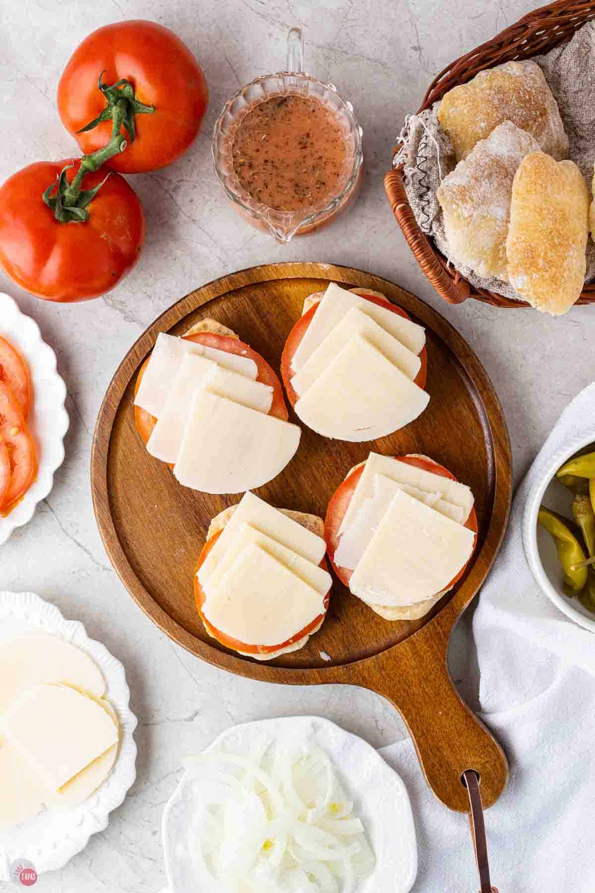 rolls on a cutting board topped with slices of cheese